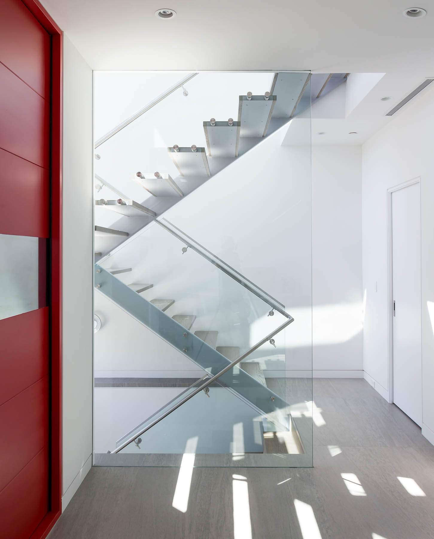 Glass-sided steel stairs with a modern design at a South Vancouver custom house.