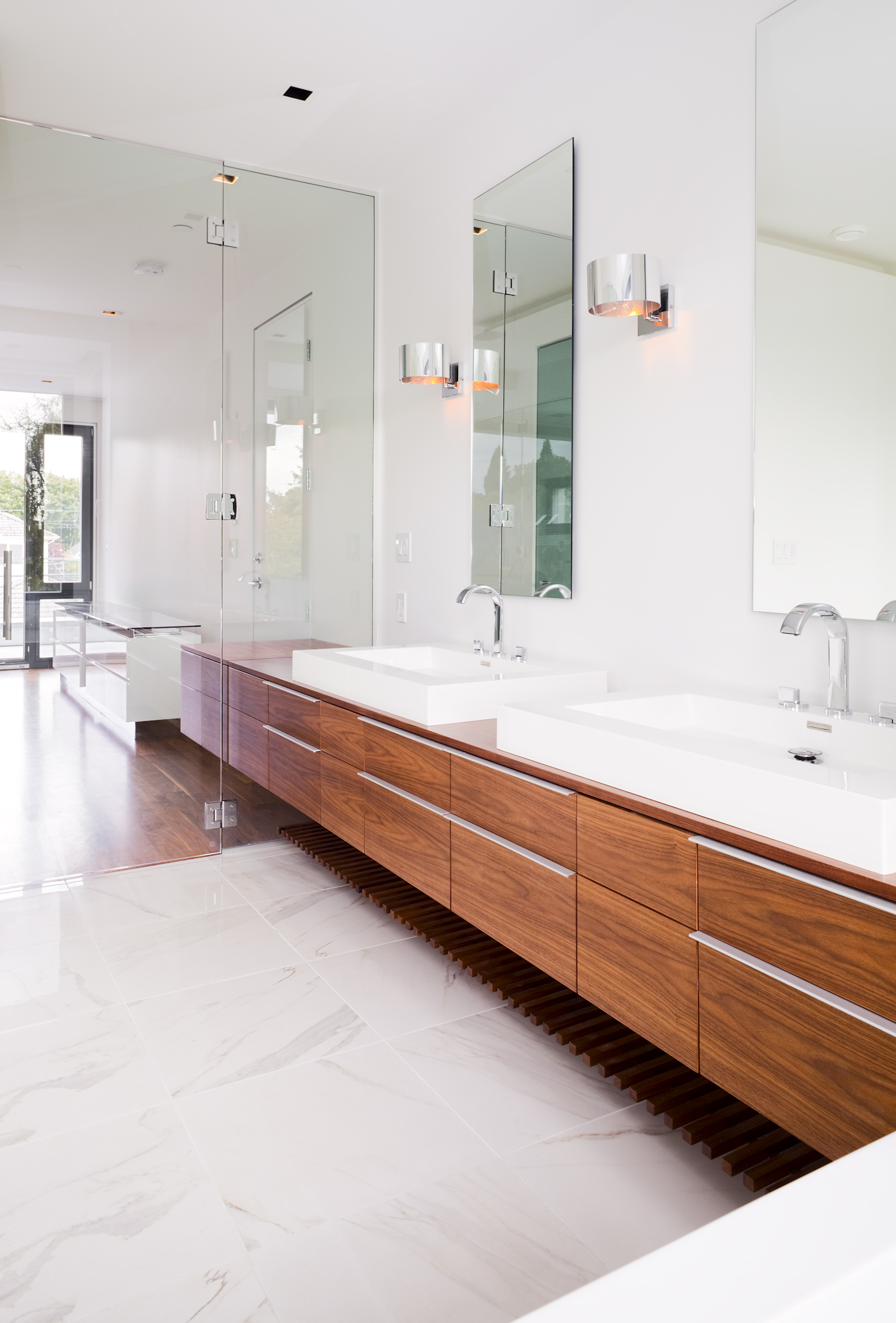 Spacious bathroom with two bathrooms and a big mirror at a custom home in Vancouver.