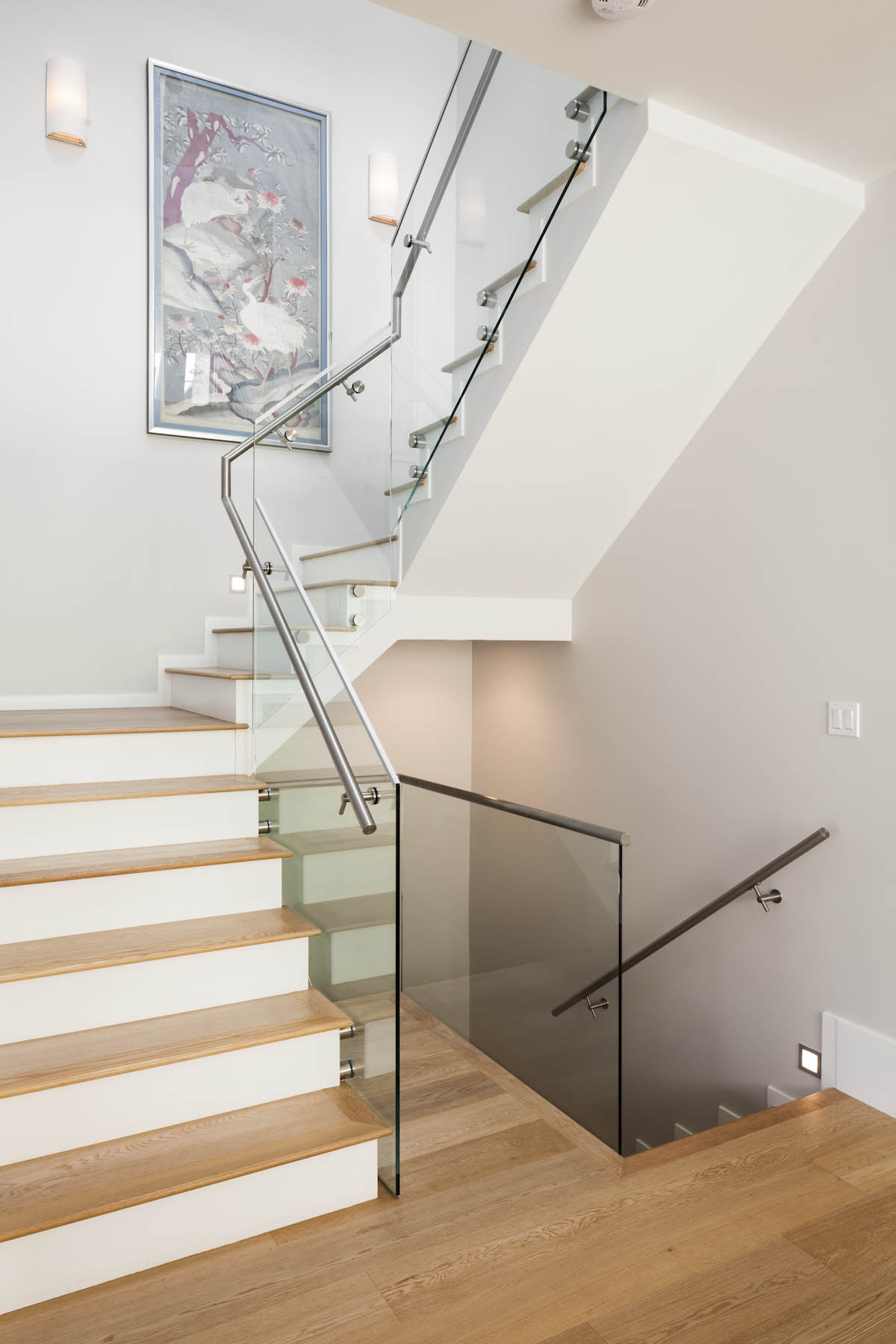 Interior glass-sided stairs with white walls at the Cambie Corridor custom house.