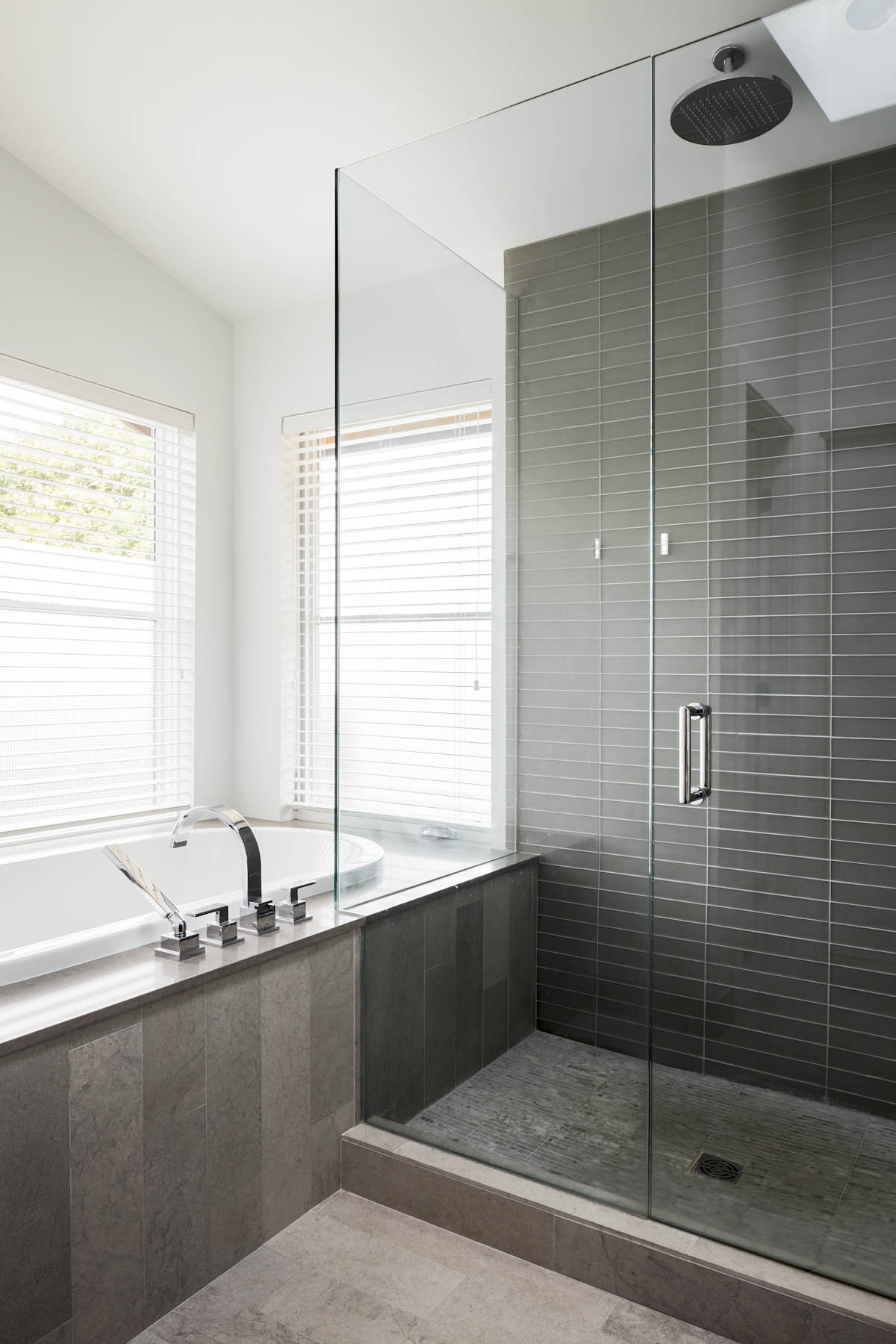 Spacious shower and bathtub with a modern design at the Cambie Corridor custom house.