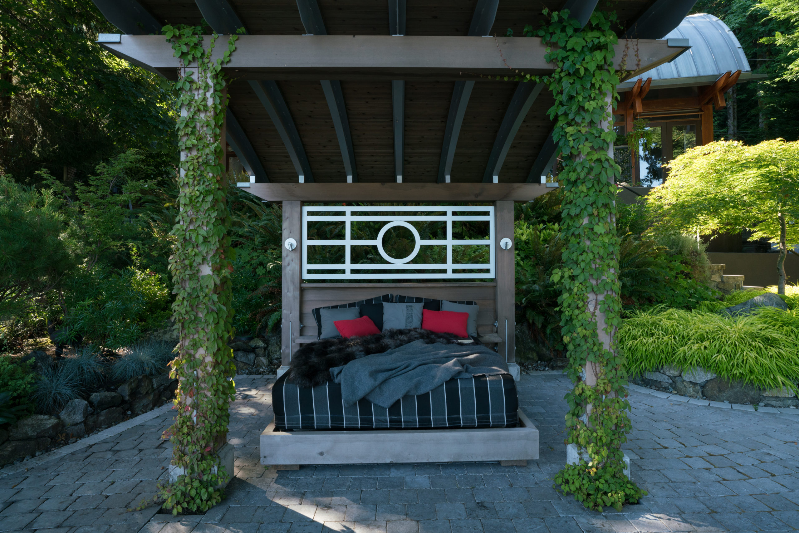 Exterior of a house with a daybed in the front yard at a custom built home on Bowen Island.