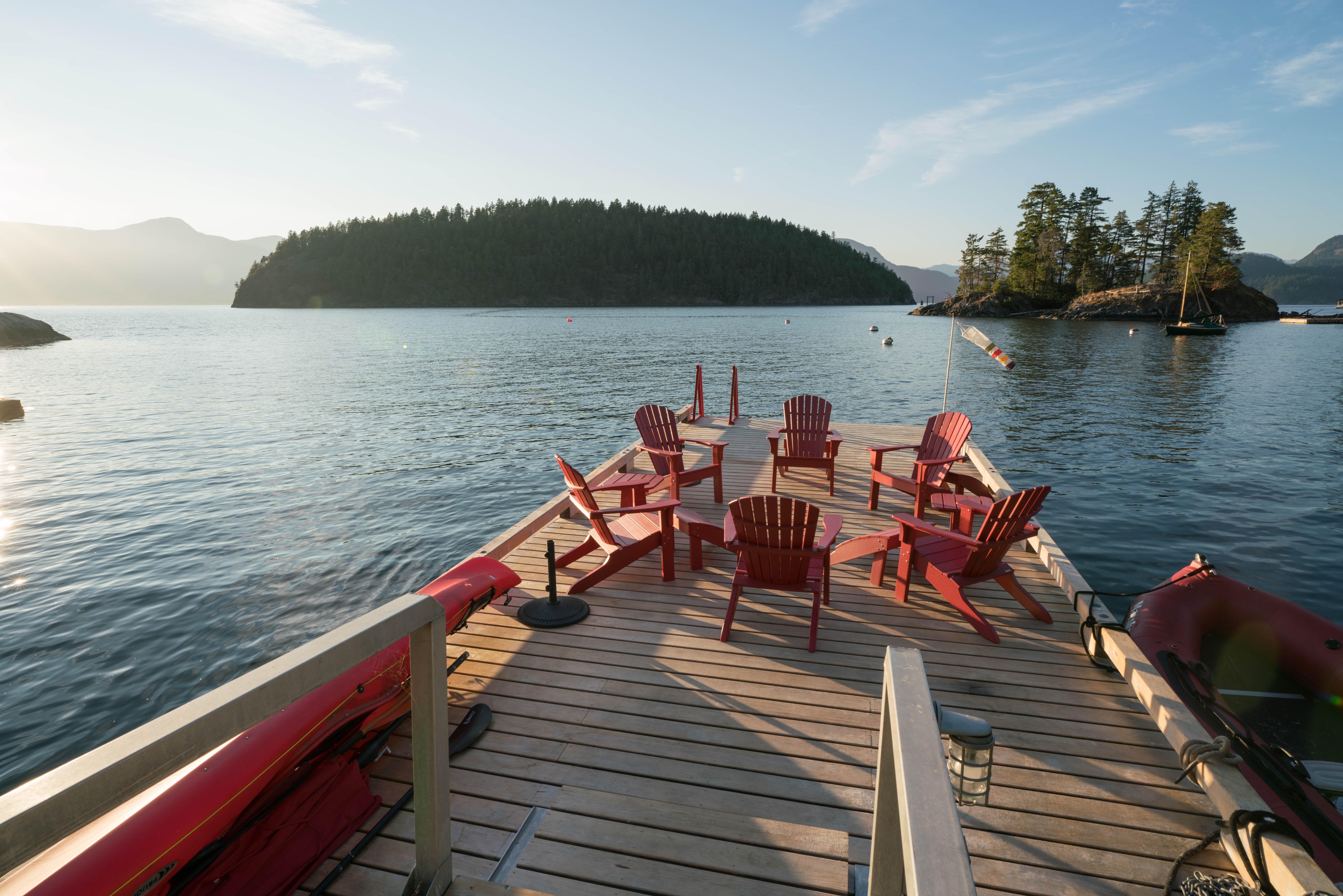 Extensive dock area with red chairs at a custom home on Bowen Island.