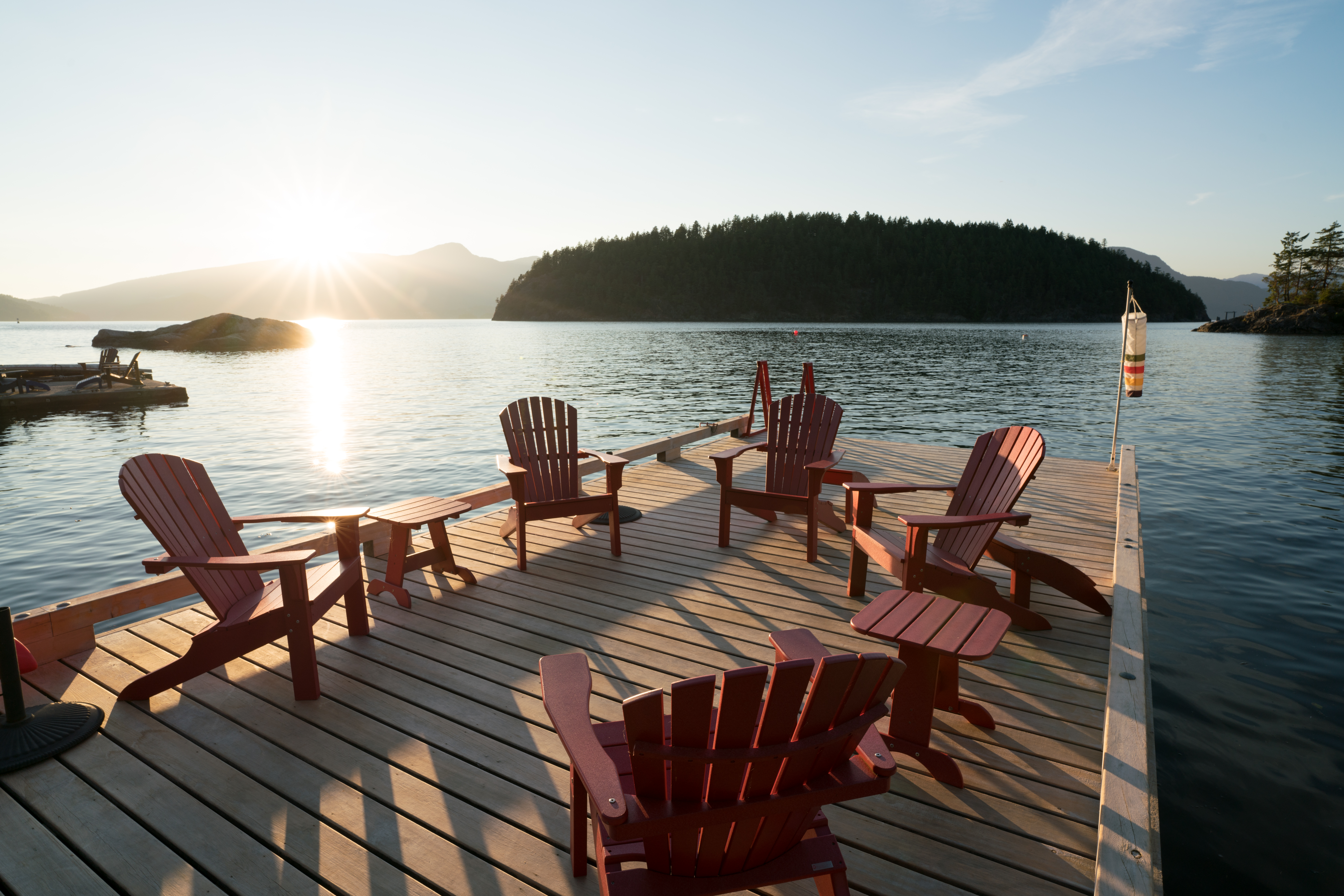 Extensive dock area with red chairs at a custom home on Bowen Island.