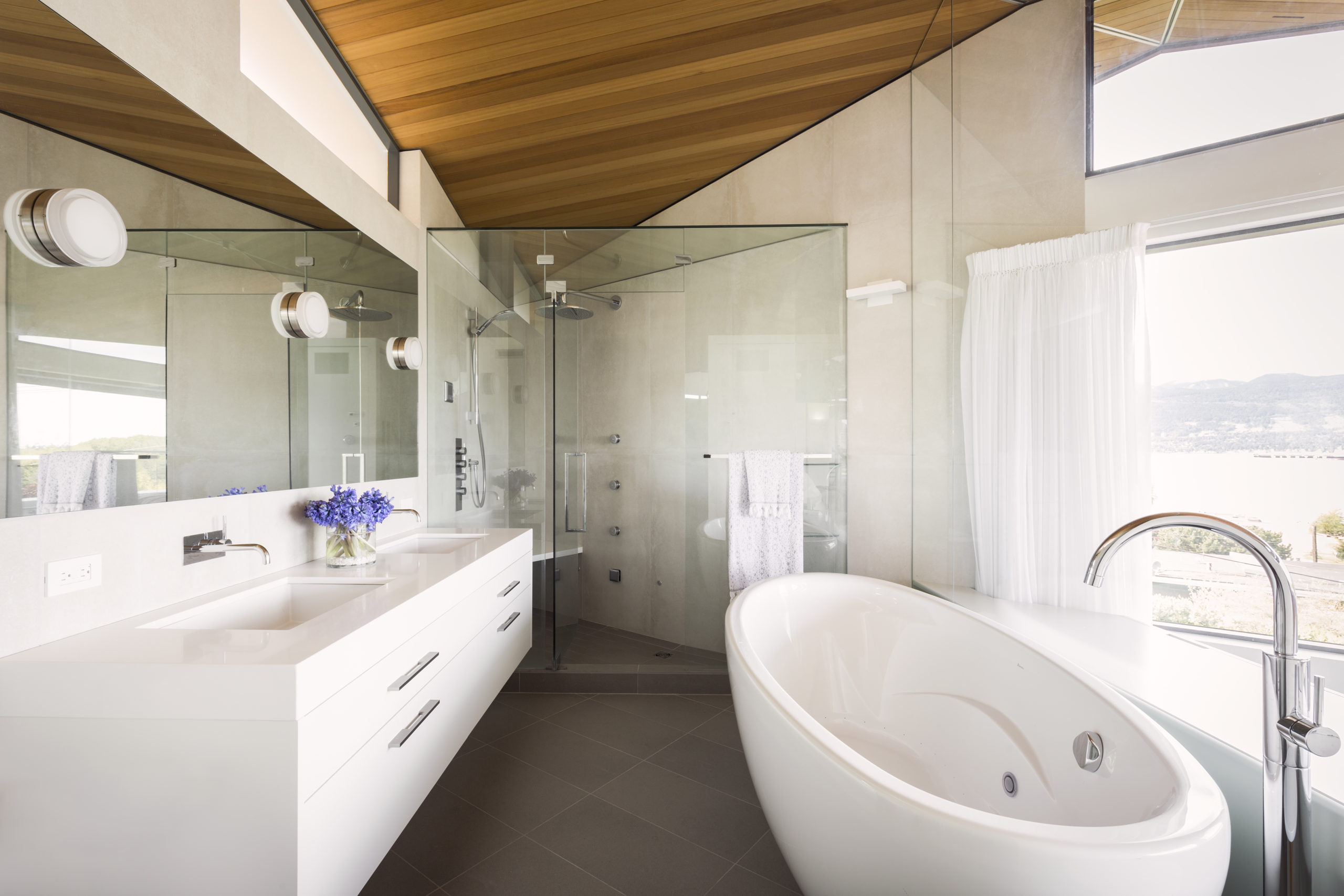 Shower and bathtub with a modern design and ocean view at our Spanish Banks custom home.