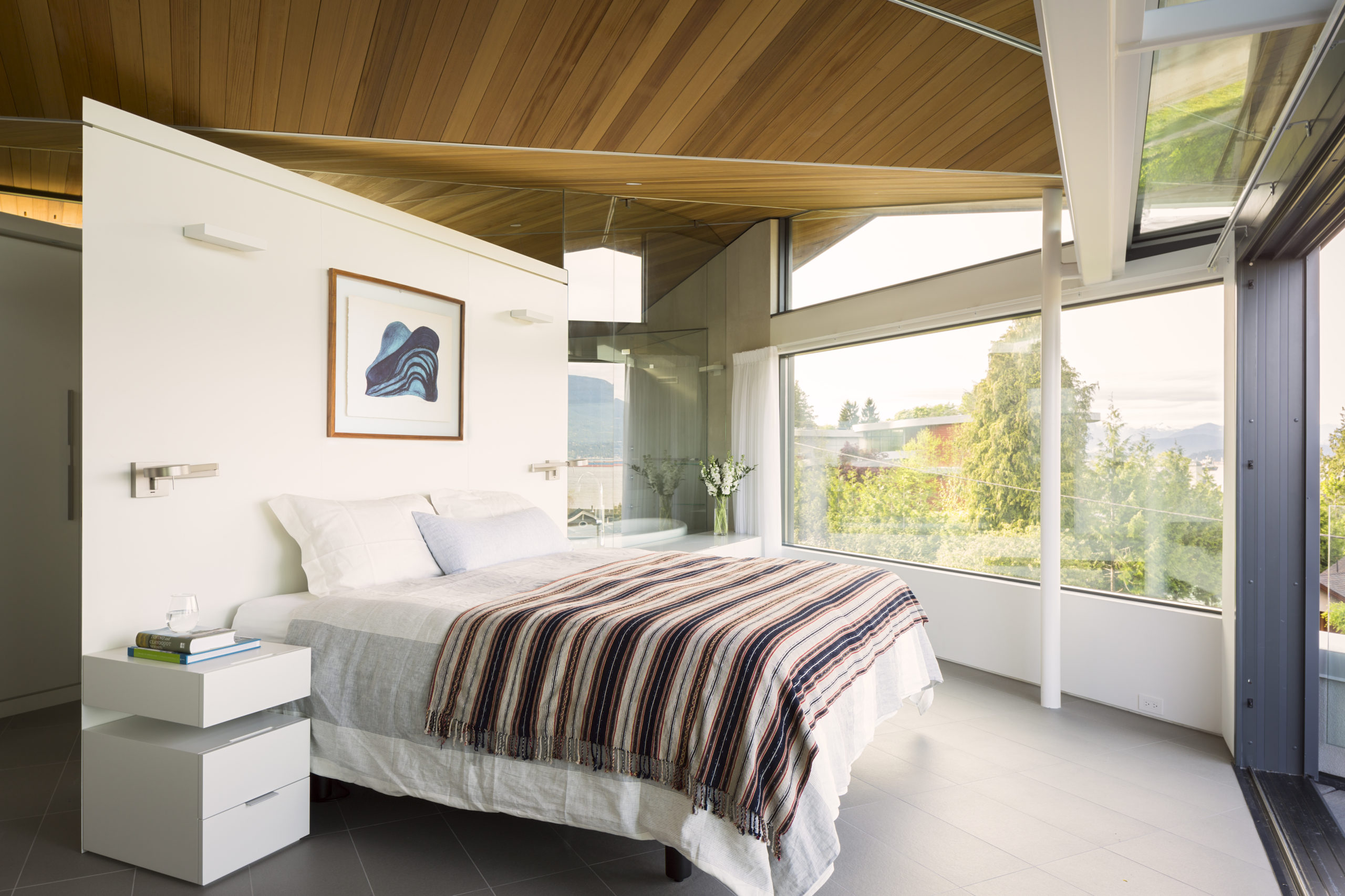 Master bedroom with a modern design and ocean view at our Spanish Banks custom home.